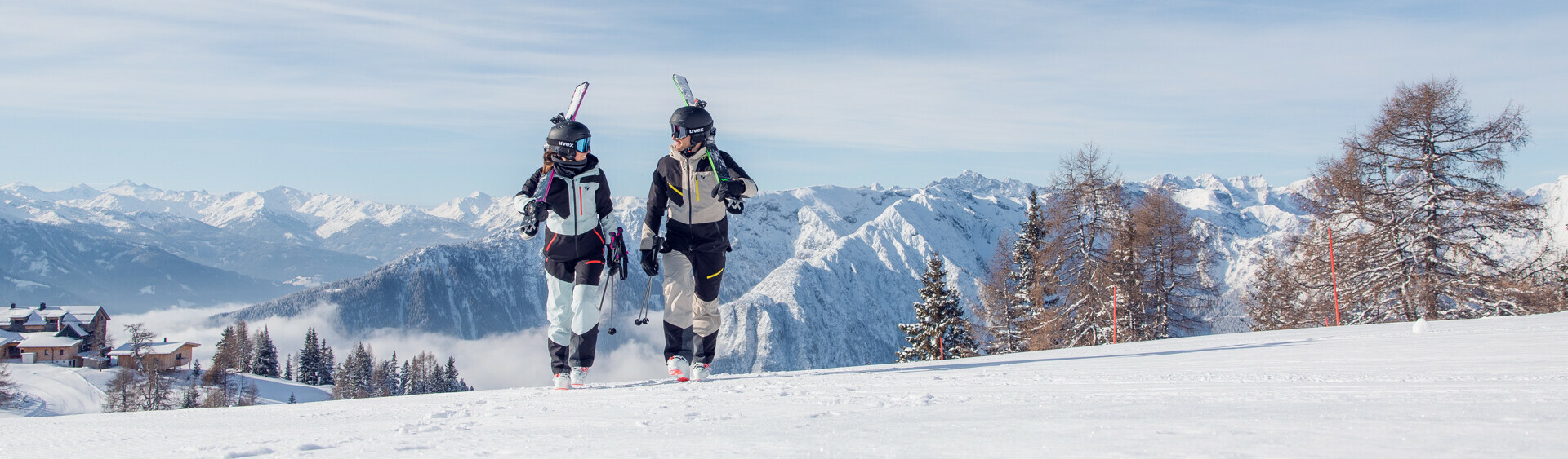 Skiers enjoy the sunny winter day on the perfectly groomed slopes of the Rofan mountains, backdropped by the snow-covered Nature Park Karwendel.