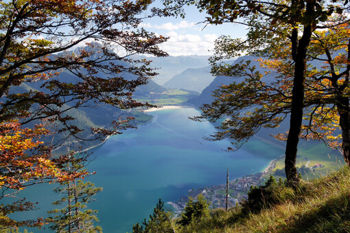 Der Herbst lässt die Naturlandschaft am Achensee in bunten Farben erstrahlen. Im Hintergrund die Ortschaft Pertisau und das Karwendelgebirge.
